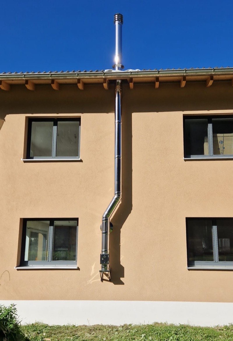 Doppelwandiger Edelstahlkamin in Hochglanz an einer Putzfassade