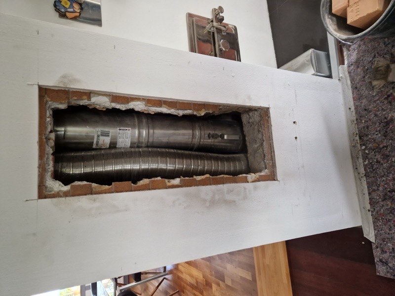 Geöffneter alter Kaminzug in der Wand vor der Sanierung